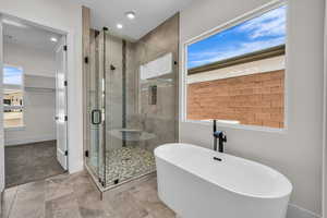 Full bath with a freestanding bath, a shower stall, and recessed lighting