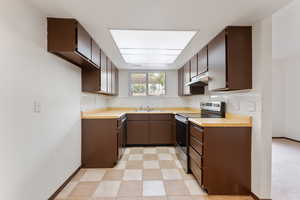 Kitchen with stainless steel appliances, under cabinet range hood, and butcher block countertops