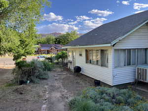 View of side of home featuring roof with shingles