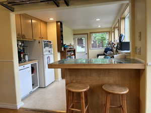 Kitchen featuring tile countertops, a kitchen breakfast bar, a peninsula, and recessed lighting