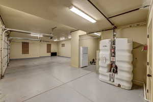 Garage with freestanding refrigerator and baseboards