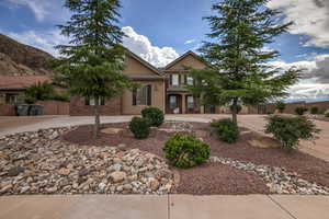 View of front facade featuring curved driveway and stucco siding