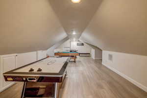 Rec room featuring vaulted ceiling, light wood-style floors, and pool table