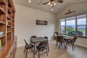 Dining room featuring vaulted ceiling, ceiling fan, light wood-style floors, and recessed lighting