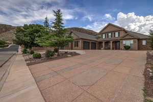 View of front facade featuring an attached garage, driveway, stucco siding, and a mountain view
