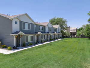 View of property North Five-Plex with a front lawn and roof with shingles