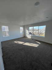 Five plex bedroom featuring panoramic windows and neutral colored carpet