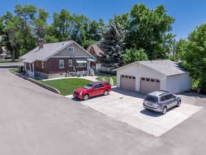 View of rear of duplex property featuring parking ,a detached garage, a rear lawn area.