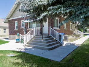 View of rear entrance to upper duplex  also below and to the left rear entrance to lower duplex facade with brick siding