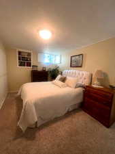 Carpeted bedroom with a textured ceiling and wooden walls