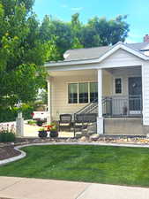 View of front of property featuring a front lawn and covered porch