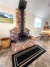 Living area featuring a wood stove and lofted ceiling