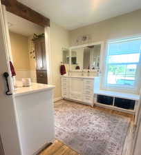 Bathroom with wood finished floors and two vanities
