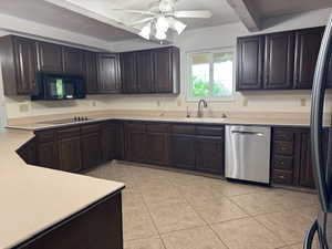 Kitchen featuring black appliances, light tile patterned floors, light countertops, ceiling fan, and dark brown cabinetry