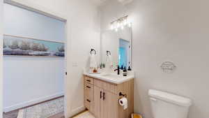 Half bathroom with vanity and wood finished floors