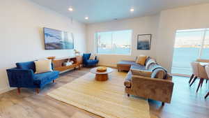 Living room with wood finished floors, healthy amount of natural light, and recessed lighting