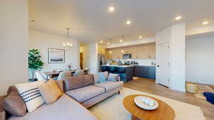Living area featuring a chandelier, light wood-style flooring, and recessed lighting