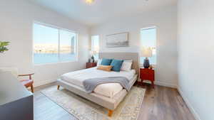 Bedroom with wood finished floors and baseboards