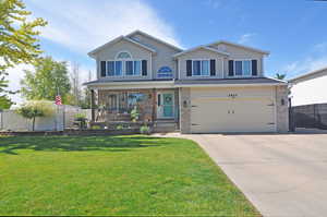 View of front of home featuring an attached garage, concrete driveway, covered porch, and brick siding