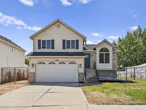Tri-level home featuring brick siding, driveway, a garage, and brand new roof and windows.