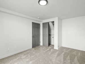 Unfurnished bedroom with carpet and a closet