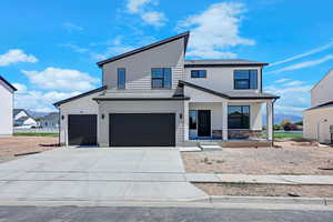 View of front of house with a porch, driveway, an attached garage, and stone siding