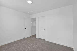 Unfurnished bedroom with carpet floors and baseboards