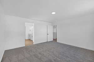 Unfurnished bedroom featuring light carpet, connected bathroom, and recessed lighting