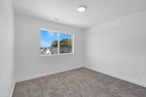 Spare room featuring carpet floors and a textured ceiling