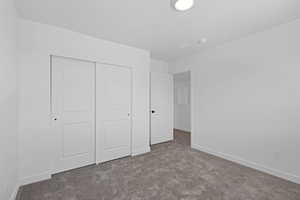 Unfurnished bedroom with carpet floors, a closet, and a textured ceiling