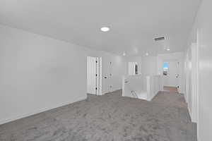 Spare room with light colored carpet and baseboards