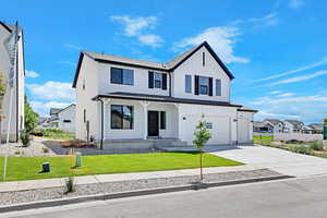 Modern inspired farmhouse featuring a porch, a front lawn, driveway, board and batten siding, and a garage