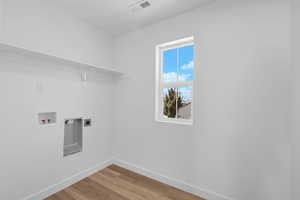 Laundry area featuring light wood-style floors, washer hookup, and hookup for an electric dryer
