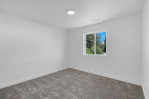 Carpeted empty room with baseboards