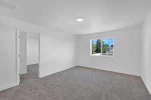 Spare room with light carpet and baseboards
