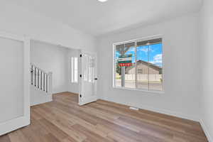 Spare room with stairway and light wood finished floors