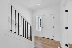 Foyer with stairs, light wood-style flooring, and recessed lighting