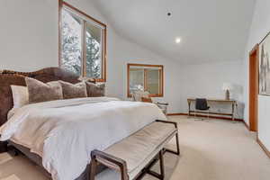 Bedroom featuring lofted ceiling and light carpet