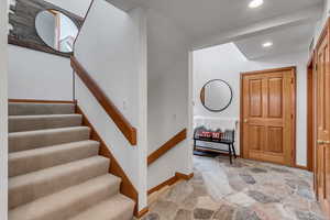 Stairway featuring stone finish floors and recessed lighting