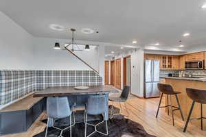 Dining area featuring light wood-style floors, recessed lighting, a chandelier, and stairs