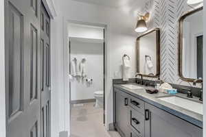 Bathroom featuring double vanity and toilet
