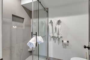 Bathroom with a shower stall and toilet