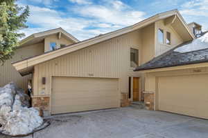 View of front of house featuring stone siding and a garage