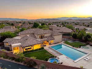 View of pool with an in-ground hot tub, a fenced backyard, and a mountain view