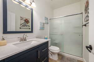 Bathroom with vanity, a shower stall, and wood finished floors