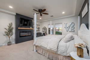 Carpeted bedroom with a large fireplace, recessed lighting, and a ceiling fan