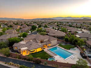 Aerial perspective of suburban area featuring a mountainous background and a pool area