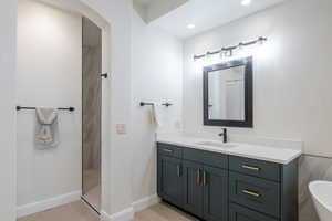 Full bath with tiled shower, vanity, tile patterned floors, and recessed lighting