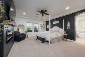 Bedroom with light carpet, recessed lighting, arched walkways, ceiling fan, and connected bathroom