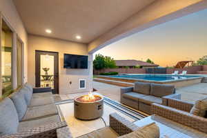 Fenced backyard featuring an outdoor living space with a fire pit and a patio area